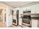 Well-lit kitchen with stainless steel appliances and white cabinets, perfect for cooking and entertaining at 6520 Roswell Rd # 79, Sandy Springs, GA 30328