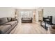 Spacious living room boasts hardwood floors, a bay window, and comfortable gray sofas at 6520 Roswell Rd # 79, Sandy Springs, GA 30328