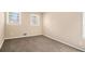 This bedroom has neutral colored walls, plush carpeting, and sunlight from two windows at 1945 Dodson Sw Dr, Atlanta, GA 30311