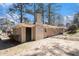 View of the home's brick exterior with a brick chimney on a partially wooded lot at 1945 Dodson Sw Dr, Atlanta, GA 30311