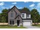 A two-story home with a gray exterior features a two car garage, set in a lush, green landscape at 4780 Briscoe Dr, Cumming, GA 30028