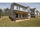 A rear exterior boasts a covered patio, stone accents, and a well-manicured lawn at 4780 Briscoe Dr, Cumming, GA 30028