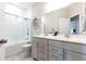 Modern bathroom featuring double sink vanity, subway tile shower with sliding glass door, and gray tile flooring at 222 Ellis Ln, Woodstock, GA 30189