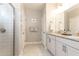 Bright bathroom with a double vanity, granite countertop, and modern tiled shower with glass door at 222 Ellis Ln, Woodstock, GA 30189