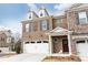 Well-maintained brick townhome featuring a two-car garage and inviting front entrance with decorative shutters and trim at 222 Ellis Ln, Woodstock, GA 30189