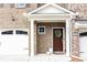 Inviting front porch of a townhome, featuring a decorative wreath on the door and well-maintained landscaping at 222 Ellis Ln, Woodstock, GA 30189