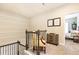 Upstairs hallway features decorative molding, a small yellow chair, and artwork displayed on the wall at 222 Ellis Ln, Woodstock, GA 30189