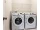 Efficient laundry room with white, front-loading washer and dryer and wire shelving at 222 Ellis Ln, Woodstock, GA 30189