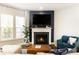 Cozy living room features a fireplace with a TV mounted above it, plus large windows for natural light at 222 Ellis Ln, Woodstock, GA 30189