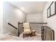 Charming loft area with an accent chair, railing, and neutral paint at 222 Ellis Ln, Woodstock, GA 30189