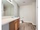 Simple bathroom featuring wood cabinets, laminate countertops, a large mirror, and vinyl floors at 4394 Estate St, Atlanta, GA 30349