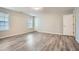 Neutral bedroom with wood-look floors, two windows, and a white door, offering a serene and spacious atmosphere at 4394 Estate St, Atlanta, GA 30349