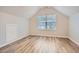 Neutral bedroom featuring wood floor, slanted ceiling, window with natural light, and built in storage at 4394 Estate St, Atlanta, GA 30349