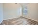 Neutral bedroom with wood-look floors, a large window, and a white door, offering a serene and spacious atmosphere at 4394 Estate St, Atlanta, GA 30349