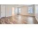 Spacious bedroom with neutral walls, wood-look flooring, two windows, and access to the Primary bathroom at 4394 Estate St, Atlanta, GA 30349
