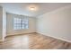 Bedroom featuring neutral walls, wood-look floors, large window, and a white door creating a spacious atmosphere at 4394 Estate St, Atlanta, GA 30349