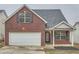 Charming two-story brick home with attached garage and manicured lawn at 4394 Estate St, Atlanta, GA 30349
