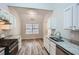 Bright kitchen with stainless steel appliances, granite countertops, white cabinets, and wood-look flooring at 4394 Estate St, Atlanta, GA 30349