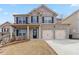 Charming two-story brick home with a two-car garage and covered front porch at 648 Ocean Ave, Canton, GA 30114