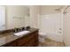 Bathroom featuring a marble countertop, dark wood cabinets, and a tub-shower combination at 76 Misty View Ln, Acworth, GA 30101