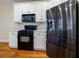 Kitchen with black appliances, white cabinets, marble countertops, and hardwood floors at 76 Misty View Ln, Acworth, GA 30101