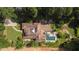 Aerial view of property featuring the tile roof, pool, lush trees and landscaping at 130 Woodlawn Ne Dr, Marietta, GA 30067