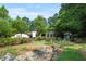 Lush backyard with trees, green grass, and a house in the background at 130 Woodlawn Ne Dr, Marietta, GA 30067