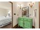 Bathroom vanity with green cabinet, vessel sink, and decorative sconces at 130 Woodlawn Ne Dr, Marietta, GA 30067