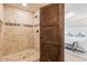 Walk-in shower with custom tile design and view into the main bedroom at 130 Woodlawn Ne Dr, Marietta, GA 30067