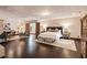 Spacious bedroom with dark wood floors, neutral walls, large bed, and sitting area at 130 Woodlawn Ne Dr, Marietta, GA 30067