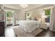 Sunlit bedroom with large bed, hardwood floors, and lush outdoor views at 130 Woodlawn Ne Dr, Marietta, GA 30067
