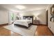 Well lit bedroom with large bed, hardwood floors, and a stylish rug at 130 Woodlawn Ne Dr, Marietta, GA 30067