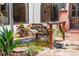 Water feature in courtyard with rocks, greenery, and a small waterfall element, adjacent to the house at 130 Woodlawn Ne Dr, Marietta, GA 30067