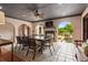 Covered outdoor dining area boasts fireplace, ceiling fan, and tranquil views of the pool area at 130 Woodlawn Ne Dr, Marietta, GA 30067