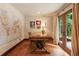 Home office with unique wooden desk, world map art and french doors to the garden at 130 Woodlawn Ne Dr, Marietta, GA 30067
