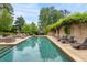 Inviting backyard pool with sun loungers, lush landscaping, and a relaxing outdoor living space at 130 Woodlawn Ne Dr, Marietta, GA 30067