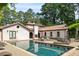 Luxury backyard featuring a pool, lounge chairs, and Mediterranean-style architecture at 130 Woodlawn Ne Dr, Marietta, GA 30067