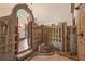 Unique shower featuring an archway, decorative stone wall, pebble floor and rustic chandelier at 130 Woodlawn Ne Dr, Marietta, GA 30067