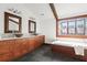 Bathroom featuring wood cabinets, stone sinks, soaking tub, and detailed window at 205 Mead Rd, Decatur, GA 30030
