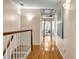 Hallway with wood floors, a wooden railing, modern lighting, and artwork at 3736 Bloxham Ct, Atlanta, GA 30341