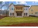 Rear exterior featuring a second story patio/balcony, a sliding glass door and a sloping yard at 4770 Briscoe Dr, Cumming, GA 30028