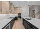 Contemporary kitchen showcases black and tan cabinetry, quartz countertops, and stainless steel appliances at 4770 Briscoe Dr, Cumming, GA 30028