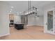 Open living space with modern light fixture and sightlines to the kitchen island with barstool seating at 4770 Briscoe Dr, Cumming, GA 30028