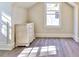 Attic room featuring hardwood floors, a dresser, and natural light streaming from an outside window at 807 Longwood Dr, Atlanta, GA 30305