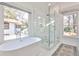 Contemporary bathroom boasts soaking tub, frameless shower, and large windows offering an outdoor view at 807 Longwood Dr, Atlanta, GA 30305