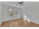 Bright and airy bedroom with hardwood floors, a ceiling fan, and a large window with outdoor views at 1040 Millridge Se Ln, Marietta, GA 30067