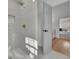 Modern tiled shower with gold fixtures and glass door, leading to a view of the main bedroom at 1040 Millridge Se Ln, Marietta, GA 30067