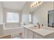 Bright bathroom with a large vanity, built-in bathtub, and ample natural light at 2685 Archer Way, Dacula, GA 30019