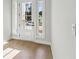 Inviting foyer with white door, sidelights, and hardwood flooring at 4480 Beechnut Cir, Cumming, GA 30028