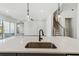 Kitchen island features a stainless sink and a black faucet with pendant lighting above at 4480 Beechnut Cir, Cumming, GA 30028